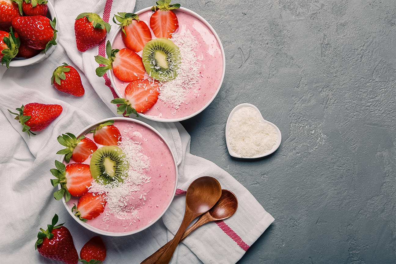 Strawberry smoothies decorated with sliced strawberries and kiwi, blog post gives a number of delicious healthy recipes for your next date night
